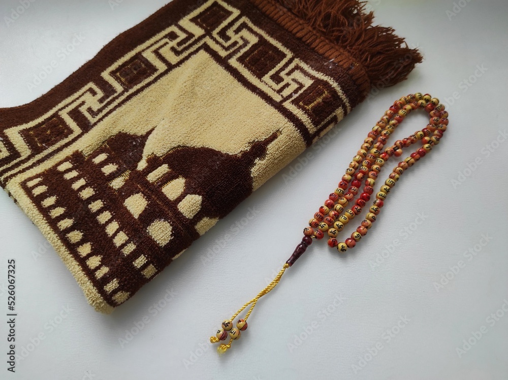 Prayer rugs and prayer beads as prayer equipment for Muslims on a white background