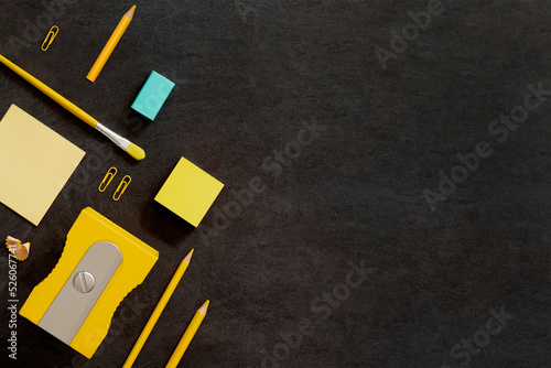Flatley, free space, copy space. Yellow and blue stationery on a black background.
