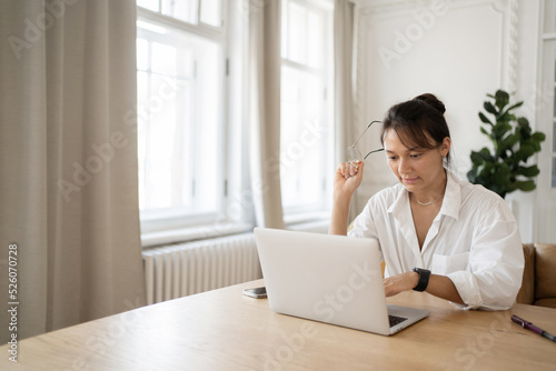 A woman works at home uses a laptop makes a report online workplace