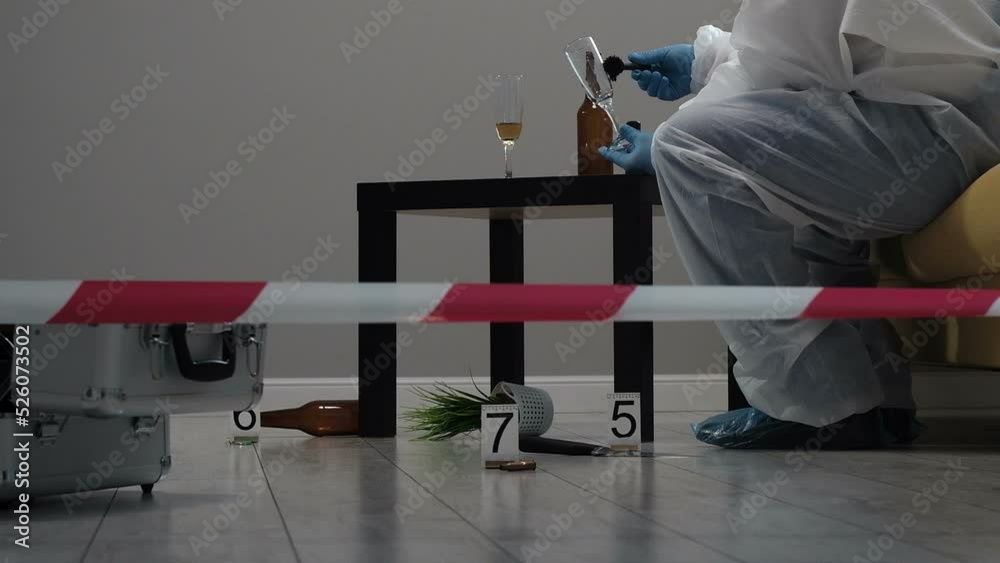 Forensic expert criminologist collects evidence at crime scene, glass ...