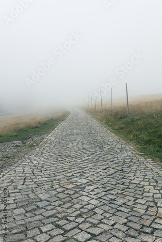 Mountain paved road that disappears into the fog