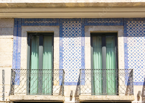 Obraz na plátně Facade of an old Portuguese house covered with azulejo tiles with windows and ba