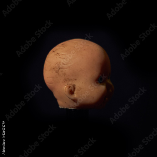 Damaged Dirty Doll head on black background
