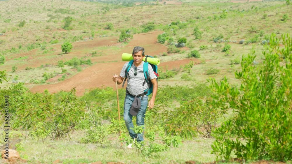 Middle aged solo hiker with support stick climbing mountain - concept of fitness or active senior people, hobby and weekend activities. Middle aged solo hiker with support stick climbing mountain - concept of fitness or active senior people, hobby and weekend activities.