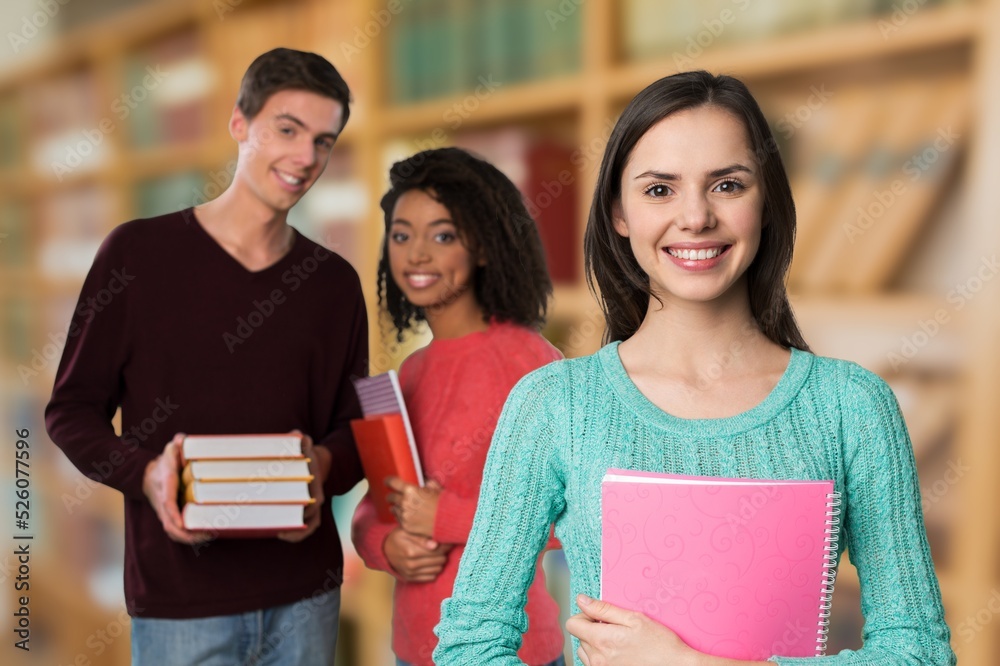 Attractive student girl standing in library, enjoy interesting effective studies in higher institution. Attractive student girl standing in library, enjoy interesting effective studies in higher institution.