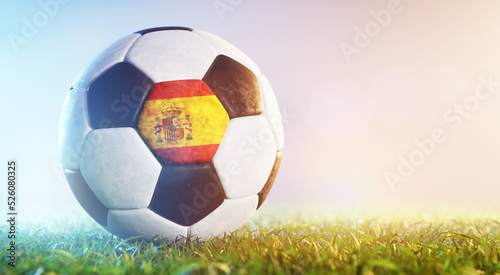 Football soccer ball with flag of Spain on grass