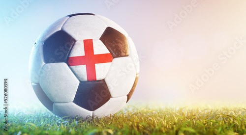 Football soccer ball with flag of England on grass