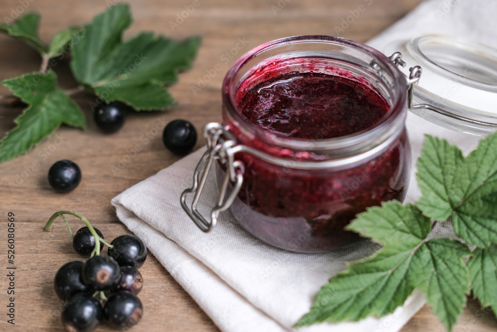 Homemade blackcurrants jam and fresh berries on a wooden background. Homemade preserving concept. Summer seasonal berry jams Homemade blackcurrants jam and fresh berries on a wooden background. Homemade preserving concept. Summer seasonal berry jams