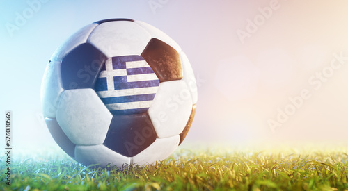 Football soccer ball with flag of Greece on grass