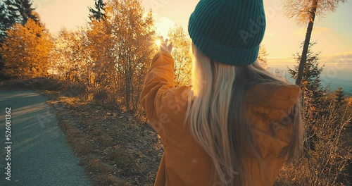 Happy Caucasian Woman enjoying, around nature, fall forest, tree. Concept follow me freedom. Female walking in woods in autumn day. Camel brown. Rusty red color. Grasses, plants, trees and parks.