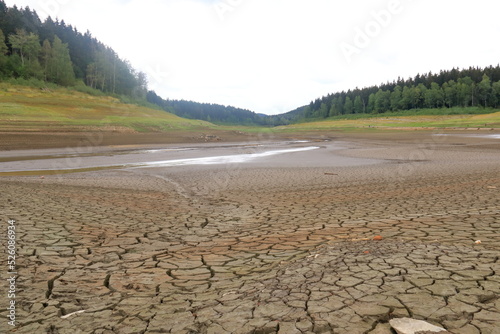 Fototapete A dried up empty reservoir and dam during a summer heatwave, low rainfall and dr