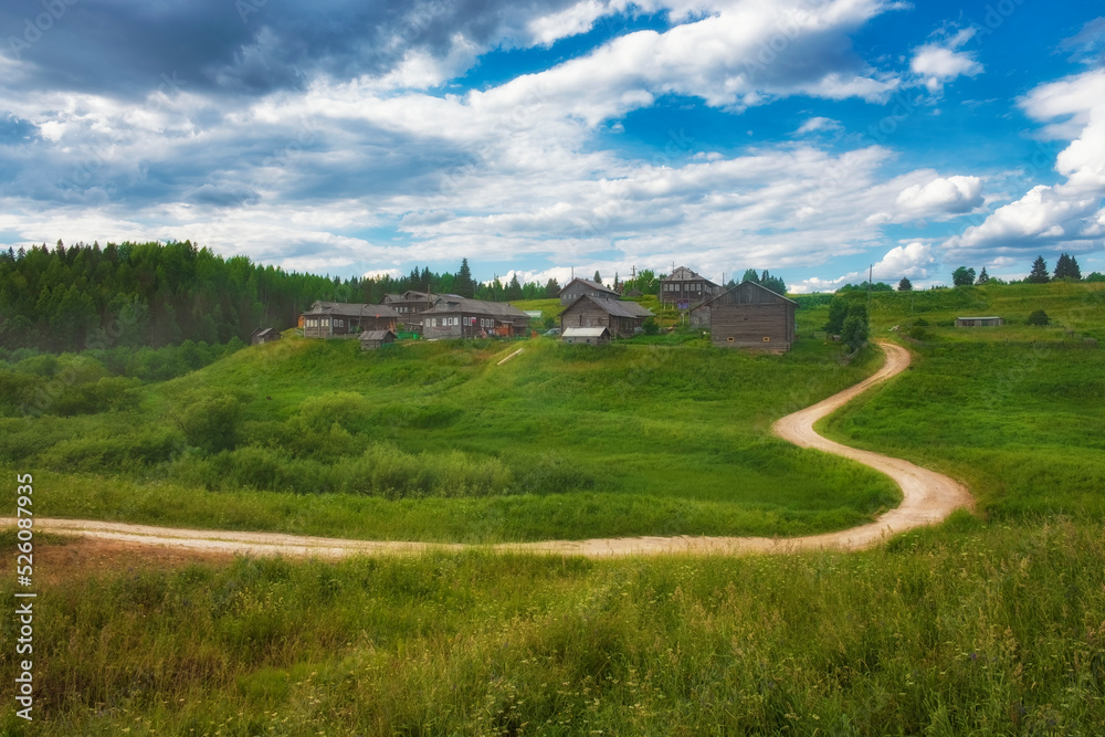 Beautiful village on a hill with wooden houses in the Arkhangelsk region in summer in Russia.