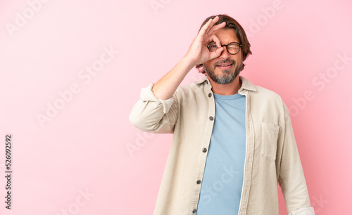 Senior dutch man isolated on pink background showing ok sign with fingers © luismolinero