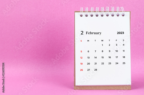 The February 2023 desk calendar on pink color background.
