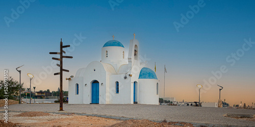 Church of St Nicholas, Kalamies in the Port Of Paralimni. Pernera. Blue and white Church on the coast of the Mediterranean sea in Cyprus against the blue morning sky. photo