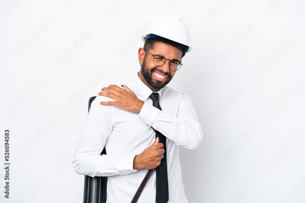Young architect Brazilian man with helmet and holding blueprints isolated on white background suffering from pain in shoulder for having made an effort Young architect Brazilian man with helmet and holding blueprints isolated on white background suffering from pain in shoulder for having made an effort