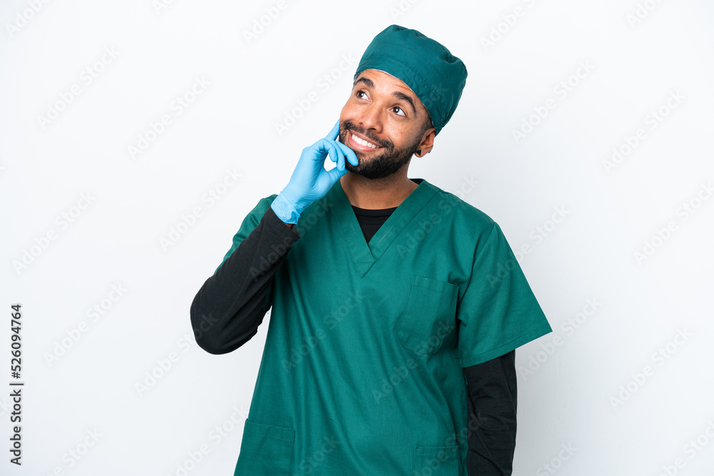 Surgeon Brazilian man in green uniform isolated on white background thinking an idea while looking up Surgeon Brazilian man in green uniform isolated on white background thinking an idea while looking up