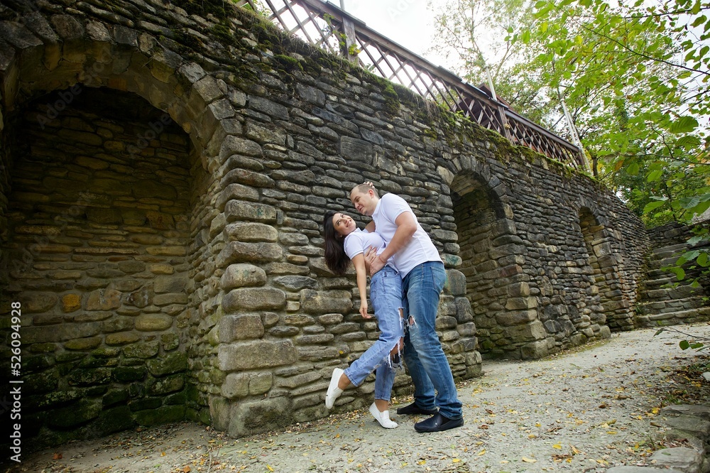 Lovers are in the Park at the stone wall.