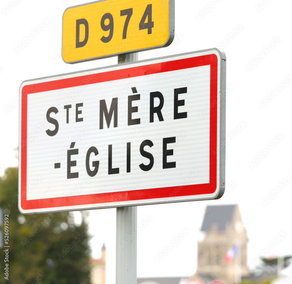 sign with the words STE MERE EGLISE in FRANCE  indicating a place of the D-DAY D-DAY landing in WWII and the bell tower in the background i