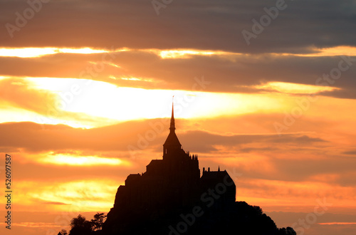 breathtaking sunset of the island with the silhouette of the abbey of Mont Saint Michel in France in the Normandy
