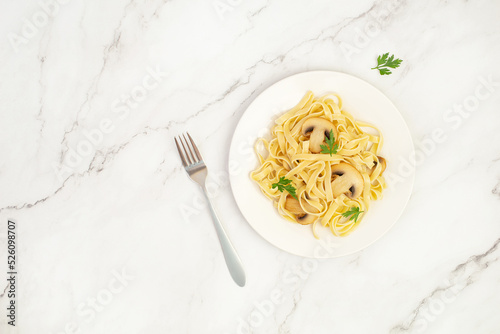 pasta with mushrooms on white marble table