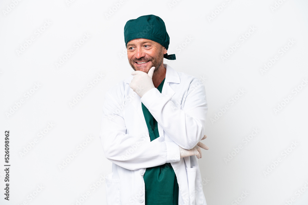 Middle age surgeon in green uniform isolated on white background looking to the side Middle age surgeon in green uniform isolated on white background looking to the side