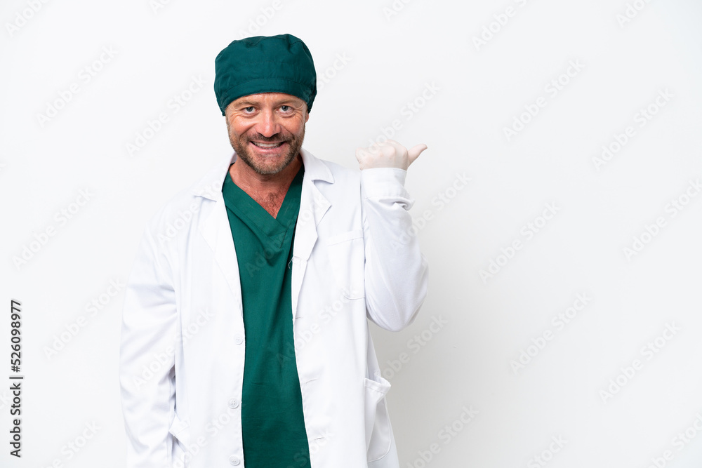 Middle age surgeon in green uniform isolated on white background pointing to the side to present a product Middle age surgeon in green uniform isolated on white background pointing to the side to present a product