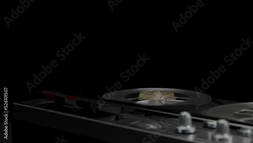 A vintage 1970s open-reel quarter-inch audio tape recorder spooling with record button depressed. Subdued lighting suggesting covert recording, wiretap, or espionage. photo