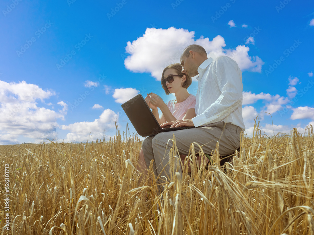 Man and woman in wheat field. Agricultural business managers. Heads agricultural company. Agro company managers with laptop. Modern farmers in wheat field. Concept software for agricultural business Man and woman in wheat field. Agricultural business managers. Heads agricultural company. Agro company managers with laptop. Modern farmers in wheat field. Concept software for agricultural business
