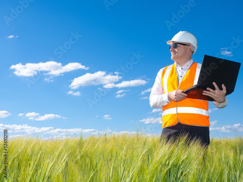 Foreman stands with laptop....