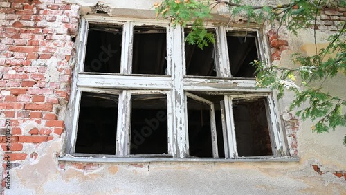 Ruined and damaged building as war aftermath. Houses destroyed and burned by artillery in war. Abandoned building village. House in ruins. Broken windows.  photo