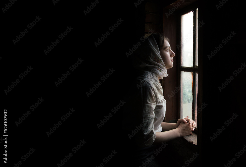 Fototapeta premium Woman praying at the window