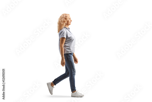 Full length profile shot of a casual woman in jeans walking