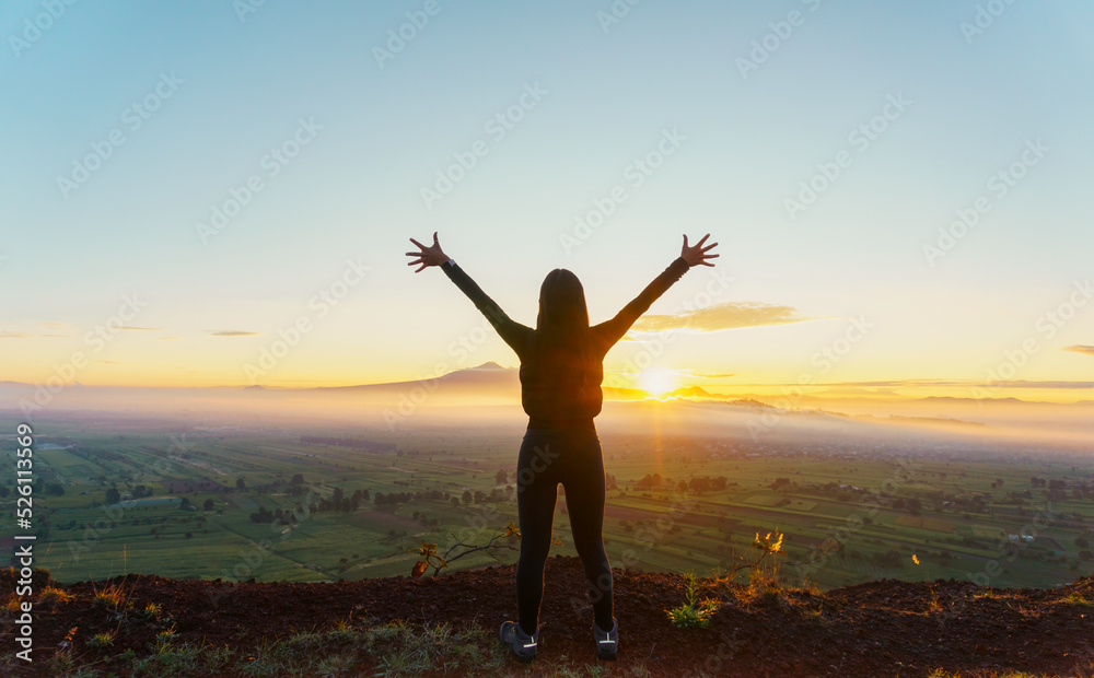 strong confidence woman open arms under the sunrise at mountain