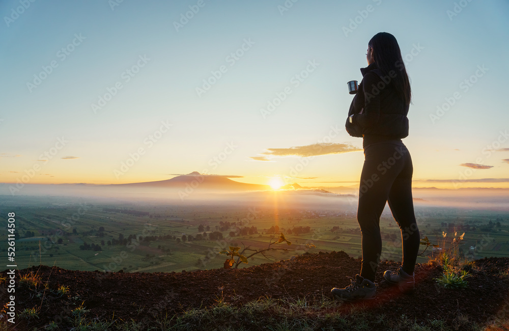 woman traveler drinks coffee with a view of the mountain landscape