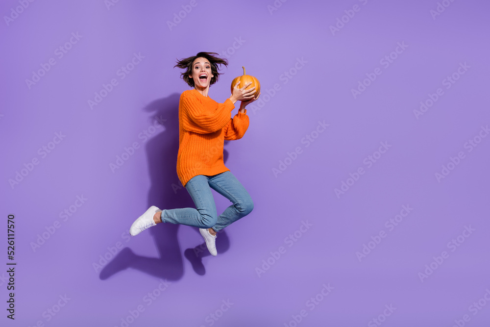 Fototapeta premium Full length body size view of lovely cheery funny girl jumping hold pumpkin having fun isolated on bright purple violet color background