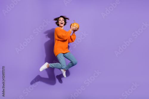 Full length body size view of lovely cheery funny girl jumping hold pumpkin having fun isolated on bright purple violet color background