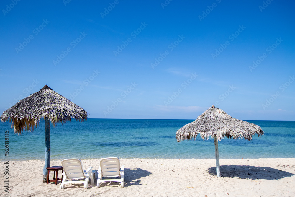 Paradise beach in Cuba with palm umbrella and clear blue water. Paradise beach in Cuba with palm umbrella and clear blue water.