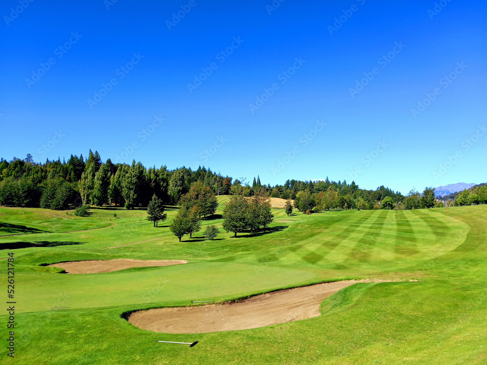 Panoramic view of golf course in Argentine Patagonia under blue sky. Nature and outdoor sports.