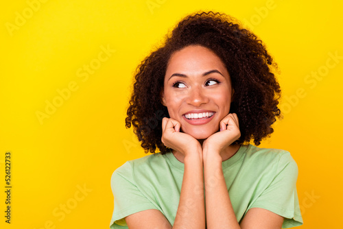 Photo of sweet brunette millennial lady hands face look up wear green t-shirt isolated on vivid yellow color background © deagreez