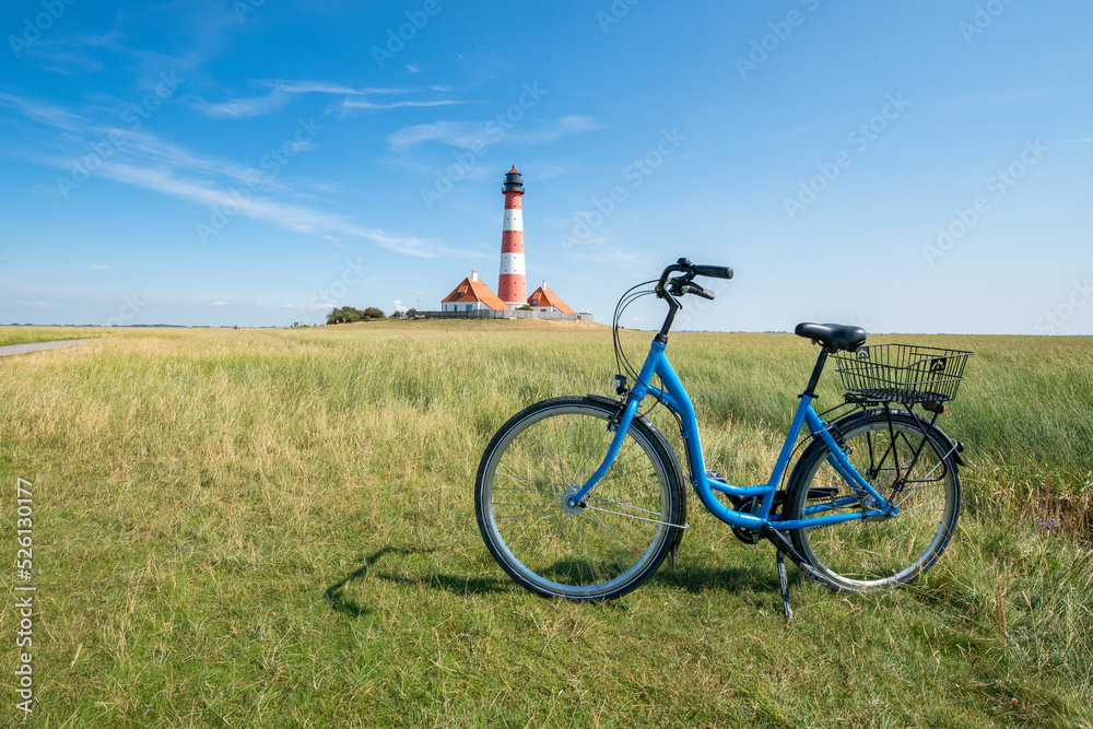 Obraz premium Bicycle tour to the Westerheversand lighthouse, Westerhever, Schleswig-Holstein, Germany