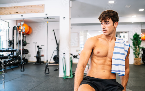 Strong male athlete taking break in gym