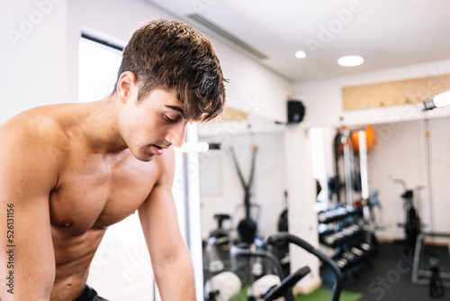 Tired sportsman taking break on exercise bike