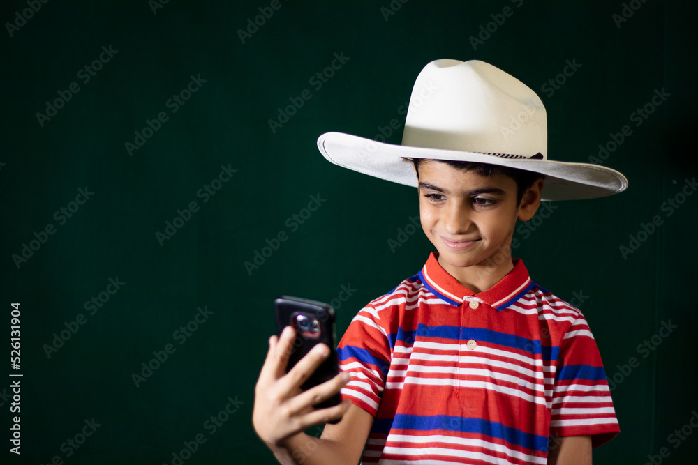 A young boy taking selfie in white cowboy hat A young boy taking selfie in white cowboy hat