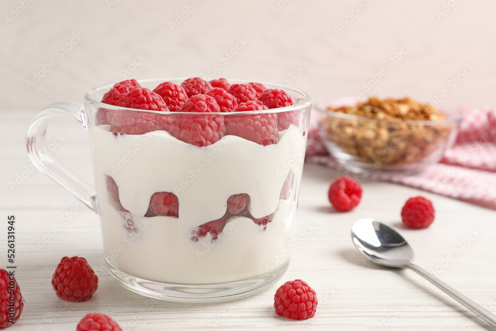 Tasty yogurt served with raspberries and muesli on white wooden table Tasty yogurt served with raspberries and muesli on white wooden table