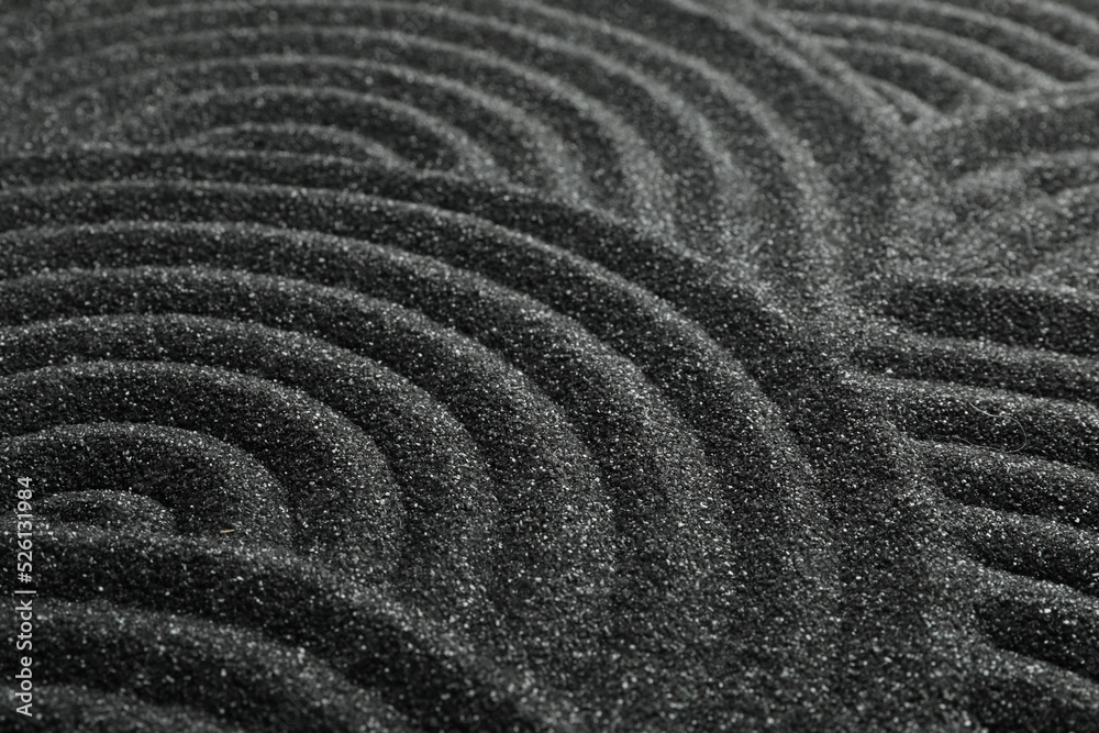 Naklejka premium Black sand with beautiful pattern, closeup. Zen concept