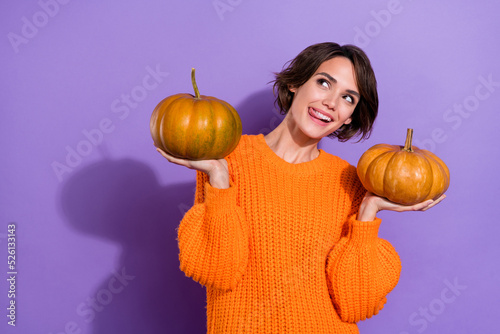 Portrait of attractive cheery curious girly girl holding pumpkins licking lip fantasizing isolated on bright purple violet color background photo