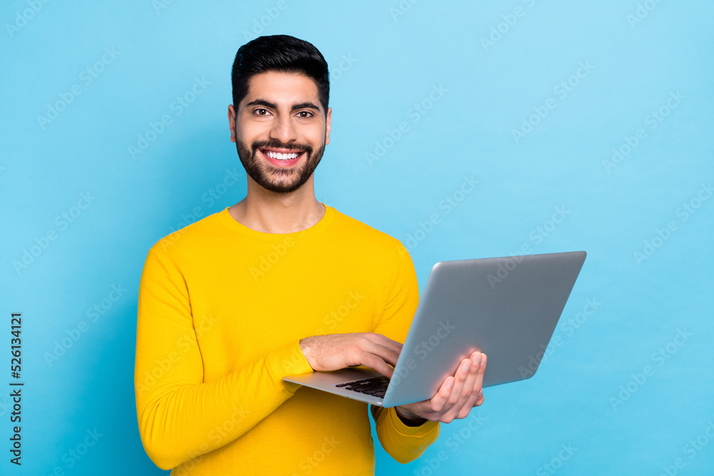 Portrait of cheerful satisfied man arms hold use wireless netbook coworking isolated on blue color background Portrait of cheerful satisfied man arms hold use wireless netbook coworking isolated on blue color background