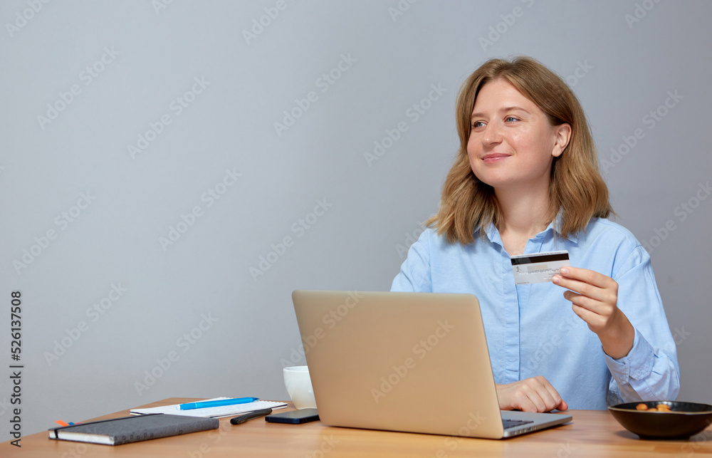 Young woman using laptop computer and holding credit card. Young woman using laptop computer and holding credit card.