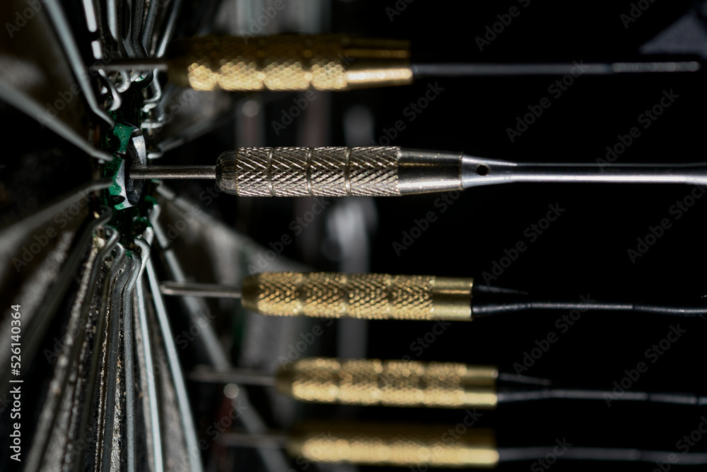Naklejka premium Lots of darts are stuck into the dartboard in a line across the center